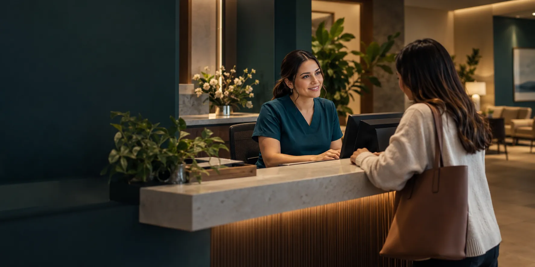 Recepcionista de una clínica conversando con una paciente en el mostrador